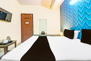 a bedroom with a large white bed and a table at Hotel O Honey Inn in New Delhi