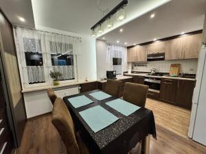 a kitchen with a table and chairs in a room at Apartament Palisadowa 78 in Wałbrzych