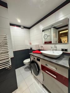 a bathroom with a sink and a washing machine at Apartament Palisadowa 78 in Wałbrzych +8 photos
