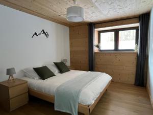a bedroom with a large bed and a window at Appartement Chalet Louison in Les Gets