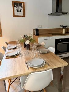 a wooden table with white plates and wine glasses at Appartement Chalet Louison in Les Gets