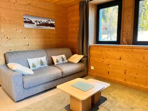 a living room with a couch and a coffee table at Appartement Chalet Louison in Les Gets
