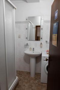 a white bathroom with a sink and a mirror at Casa 'Saudade' in Moura