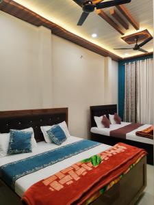 a bedroom with two beds and a ceiling at Akshayavat Palace in Ayodhya