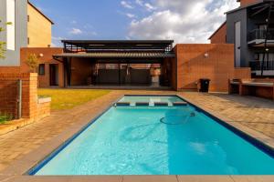 a swimming pool in the backyard of a house at The Waterfallcity Charm next to Mall of Africa in Midrand