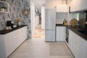 a kitchen with white cabinets and black counter tops at Petite Perle by Port Azur Rental in Cogolin +16 photos