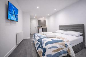 a bedroom with a large bed and a flat screen tv at Seamflow Homes - Folkestone, near Eurotunnel - Channel Tunnel in Folkestone