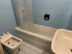 a bathroom with a toilet and a tub and a sink at La Santiaga Sólo para chicas in Córdoba