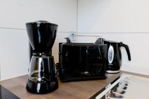 a black coffee maker sitting on top of a counter at Komfort Ferienwohnungen Zwenkauer See in Zwenkau