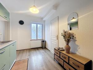 a kitchen with a vase of flowers on a wooden table at Cosy & Charmant - centre et tranquillité in Erstein +5 photos