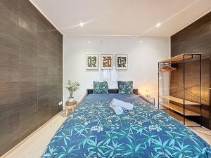 a bedroom with a large bed with a blue blanket at Cosy & Charmant - centre et tranquillité in Erstein
