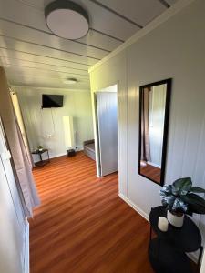 a room with a hallway with a hard wood floor and a mirror at Cabaña BosKaL in Quesada