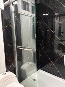 a glass shower in a bathroom with a toilet at Cabaña BosKaL in Quesada +16 photos