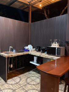 a kitchen with a counter with a microwave and a sink at Cabaña BosKaL in Quesada