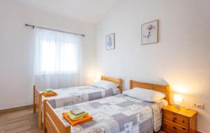 a bedroom with two beds and a window at Apartman mirna lokacija s pogledom i parkingom in Vodnjan