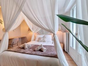 a bedroom with a canopy bed with pillows on it at La Suite BALI, Charme et Confort, Hyper centre in La Roche-sur-Yon