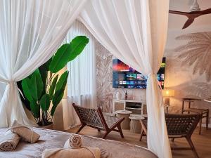 a bedroom with a bed with white curtains and a desk at La Suite BALI, Charme et Confort, Hyper centre in La Roche-sur-Yon