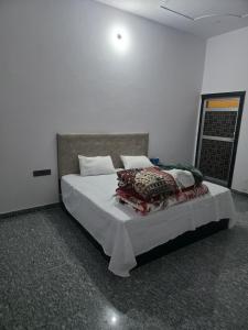 a bedroom with a bed with white sheets and pillows at Red diamond palace in Sīkar