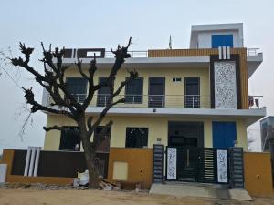 a building with a tree in front of it at Red diamond palace in Sīkar