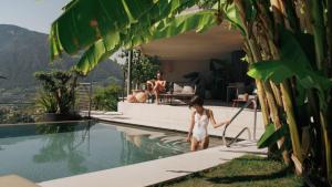 Eine Frau steht an einem Schwimmbecken in der Unterkunft Boutique Hotel Eschenlohe Adults only in Schenna