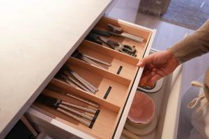 a person reaching into an open drawer in a refrigerator at Design Apartment Plön in Plön +73 photos