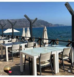 a row of tables with umbrellas and the ocean at Lamoya Suites in Silifke +4 photos