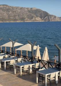 a row of tables and chairs on a dock near the water at Lamoya Suites in Silifke