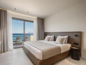 a bedroom with a bed with a view of the ocean at Sunny Bay Hotel in Kissamos +50 photos