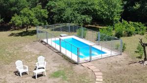 a cage around a swimming pool with two chairs at Las Toribias II in El Rincón
