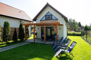 a group of chairs sitting on a lawn in front of a house at Domki Górkło in Górkło