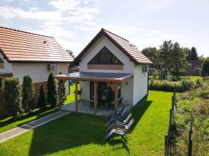 a house with a pitched roof with a patio at Domki Górkło in Górkło