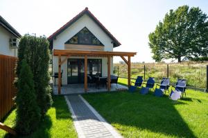 a house with a table and chairs in the yard at Domki Górkło in Górkło