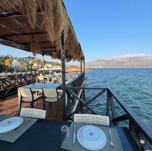 a restaurant on the water with tables and chairs at Lamoya Suites in Silifke