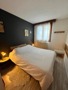 a bedroom with a large white bed with a window at Praloup 1600 t3 sur piste 4p in Uvernet