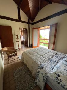 a bedroom with a large bed and a window at Canto do Cururuá - IlhaBela in Ilhabela