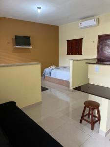 a bedroom with a bed and a tv on the wall at Pousada Maracajaú in Maracajaú