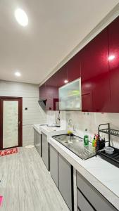 a kitchen with a sink and red cabinets at Jati Homestay Batam Center in Batam Center