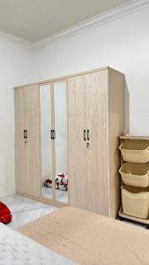a bedroom with wooden cabinets and a mirror at Jati Homestay Batam Center in Batam Center