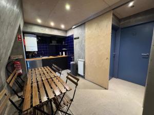 a room with a wooden bench and a kitchen at Sardines Rooms & Apartment in Póvoa de Varzim +22 photos