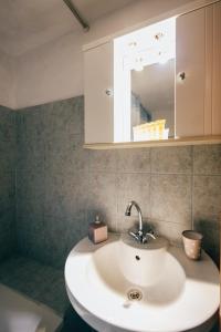 ein Badezimmer mit einem weißen Waschbecken und einem Spiegel in der Unterkunft Michel Studios in Kalavryta + 66 Fotos