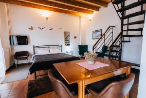 ein Schlafzimmer mit einem Bett und einem Tisch mit Stühlen in der Unterkunft Michel Studios in Kalavryta