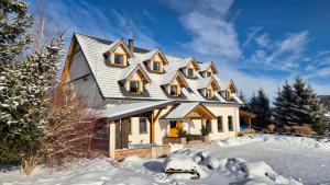 a house with a gambrel roof in the snow at Miodówka in Stronie Śląskie