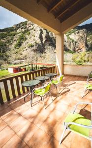 eine Terrasse mit Tischen und Stühlen auf einem Balkon in der Unterkunft Michel Studios in Kalavryta