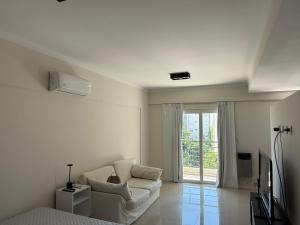 a white living room with a couch and a tv at Monoambiente Premium in La Plata