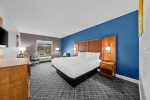 a hotel room with a large bed and a blue wall at Comfort Inn & Suites Plainville-Foxboro in Plainville +36 photos