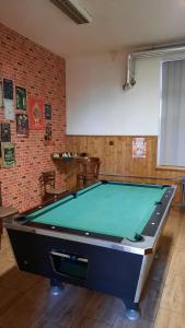 a pool table in a room with a brick wall at Apartmán Eliška v Karolince in Karolinka