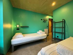 a room with two beds and a green wall at Sardines Rooms & Apartment in Póvoa de Varzim