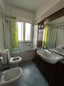 a bathroom with two sinks and a toilet and a mirror at Casa Gioia in Besano +9 photos