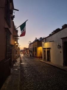 a flag flying in a street at sunset at Hacienda de las Flores in San Miguel de Allende +120 photos