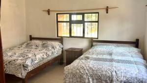 a bedroom with two beds and a window at La isla encantada in Aculco de Espinoza